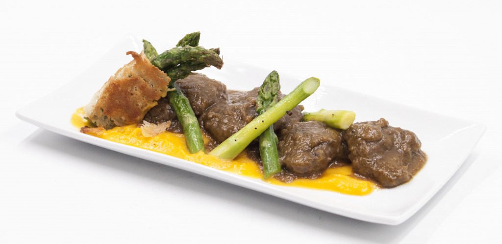 Carrillera de cerdo con crema de calabaza y amareto, puntas de espárragos verdes y chips de tubérculos